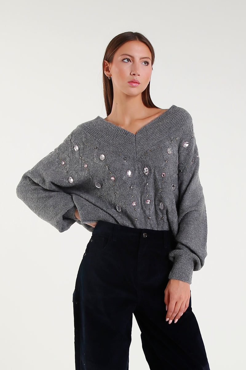 Maglia grigia con scollo a V e applicazioni gioiello